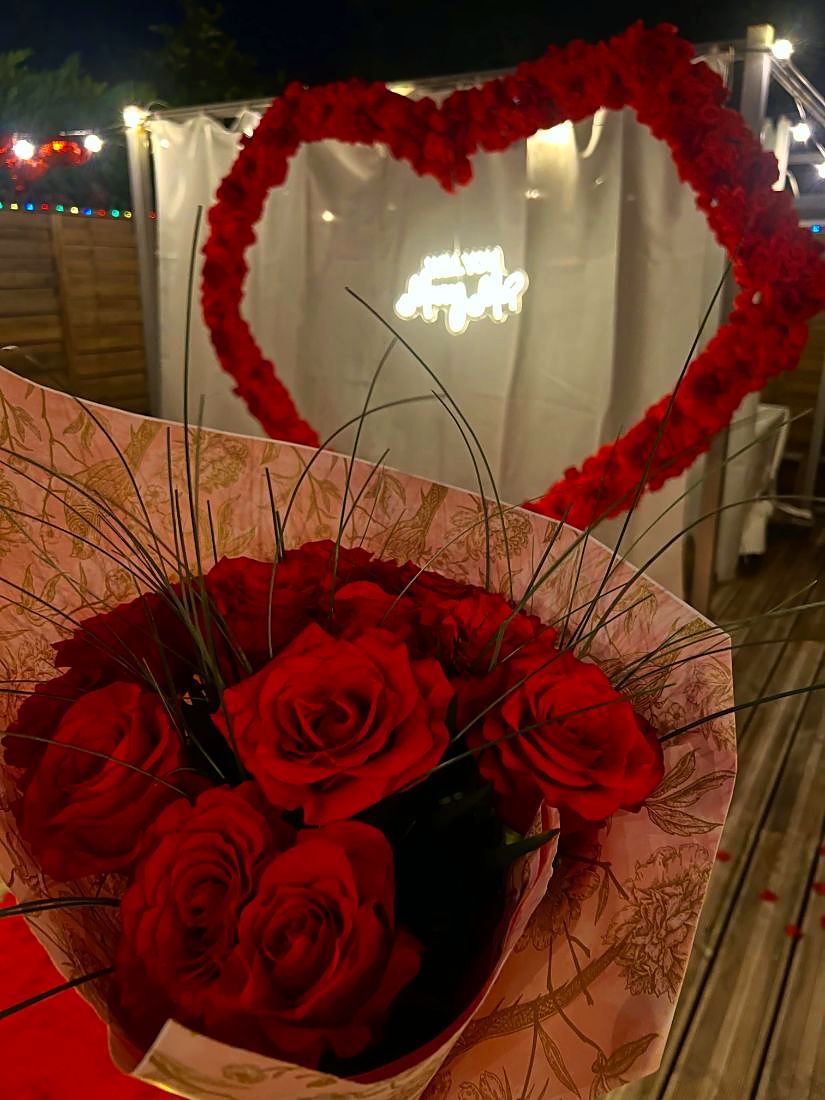 Bouquet de roses rouges devant le cœur de la demande en mariage