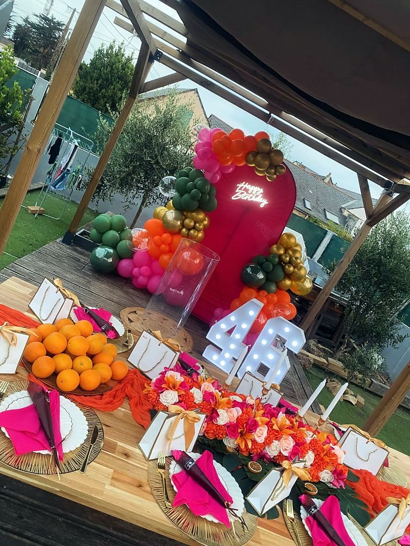 Décor tropical installé en terrasse : arche, ballons et table dressée